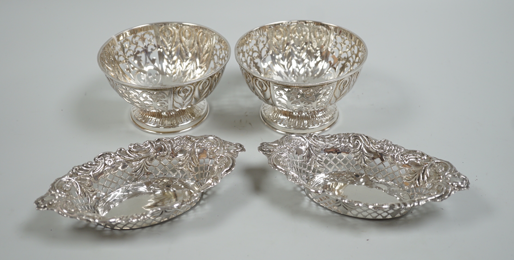 A modern pair of pierced silver circular bowls, by C.J. Vander Ltd, diameter 10.8cm and a pair of late Victorian silver bonbon dishes, 10oz.